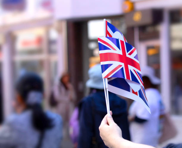 hand proudly holding up 2 union jack flags